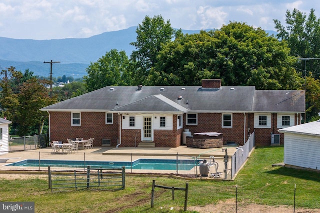 view of swimming pool featuring a mountain view, a lawn, and a patio