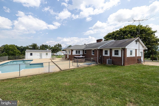 exterior space featuring a patio area, cooling unit, a lawn, and a hot tub