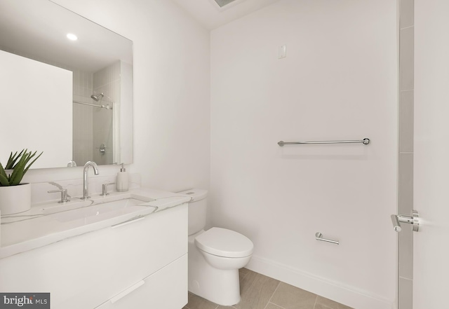 bathroom featuring a shower, baseboards, vanity, and toilet