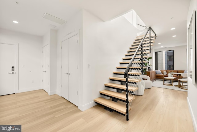 stairs with recessed lighting, baseboards, and wood finished floors