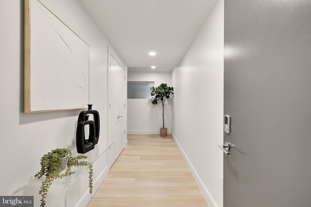 hall with recessed lighting, light wood-style flooring, and baseboards