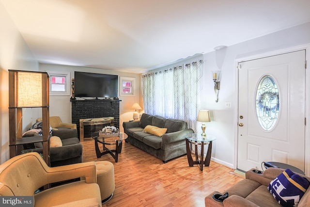 living room featuring plenty of natural light, light wood-type flooring, and baseboards