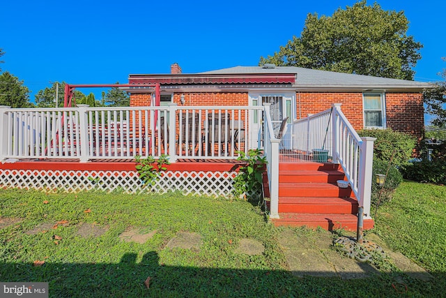 view of front facade featuring a deck, brick siding, and a chimney