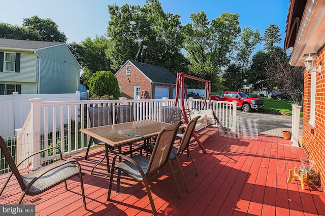 wooden deck with outdoor dining area and an outbuilding