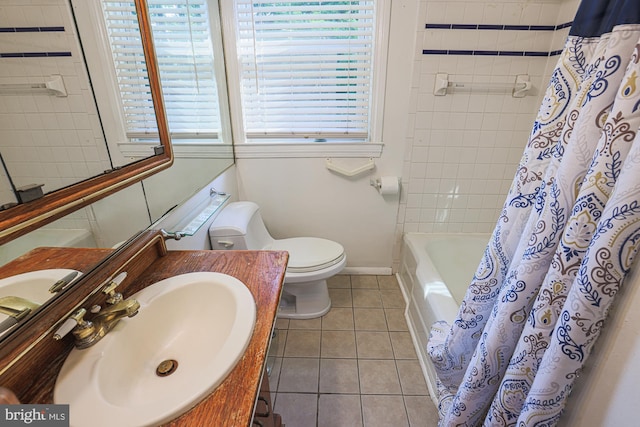 bathroom featuring baseboards, toilet, tile patterned floors, shower / bathtub combination with curtain, and a sink