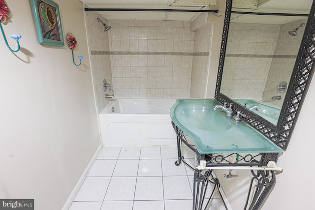 bathroom featuring shower / bathtub combination, baseboards, a sink, and tile patterned floors