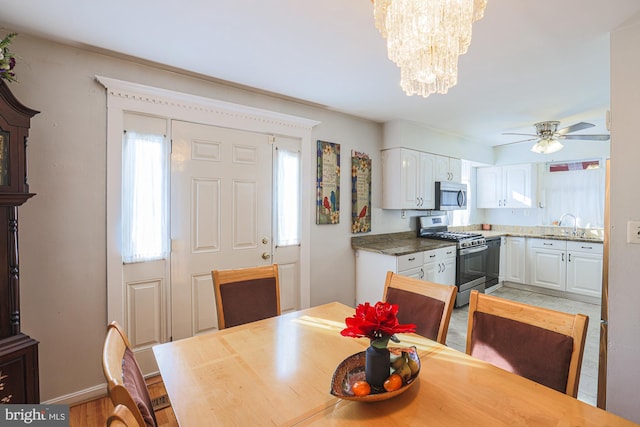 dining space featuring ceiling fan with notable chandelier