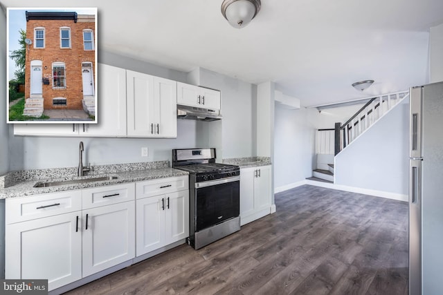 kitchen with sink, appliances with stainless steel finishes, white cabinetry, dark hardwood / wood-style floors, and light stone countertops