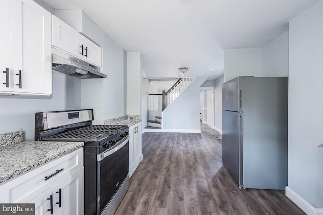 kitchen featuring white cabinetry, appliances with stainless steel finishes, light stone counters, and dark hardwood / wood-style flooring