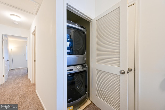 washroom featuring stacked washer and clothes dryer and light carpet