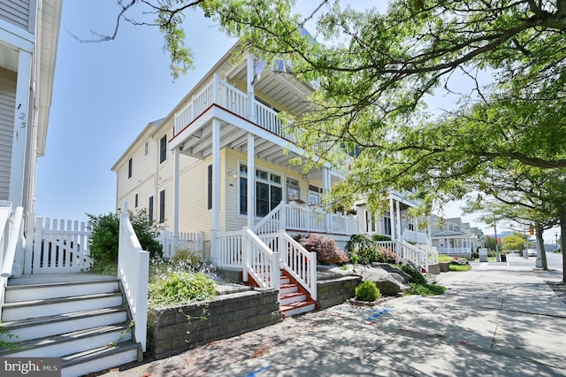 view of front of property featuring a balcony and covered porch