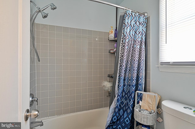 bathroom featuring shower / tub combo with curtain and toilet