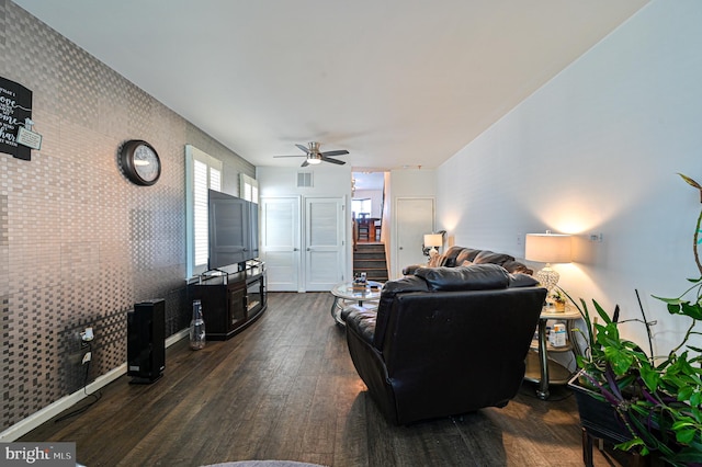 living room featuring ceiling fan and dark hardwood / wood-style floors