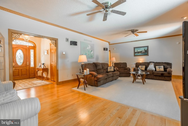 living room with ceiling fan, light hardwood / wood-style floors, a textured ceiling, and crown molding