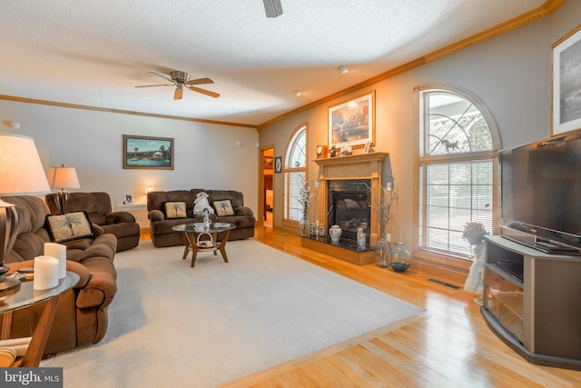 living room featuring ceiling fan, crown molding, and light hardwood / wood-style floors