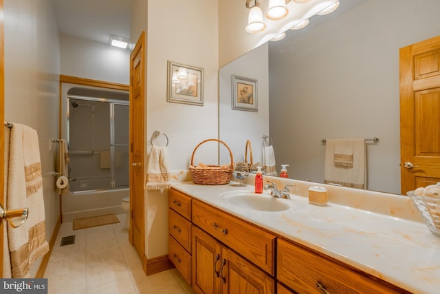 full bathroom featuring tile patterned floors, toilet, vanity, and enclosed tub / shower combo