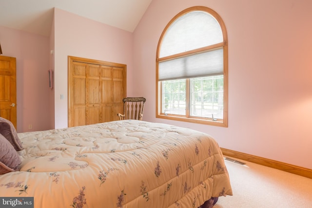 carpeted bedroom featuring baseboards, visible vents, a closet, and lofted ceiling