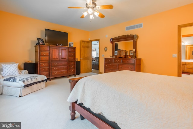 bedroom featuring ceiling fan, connected bathroom, and light carpet