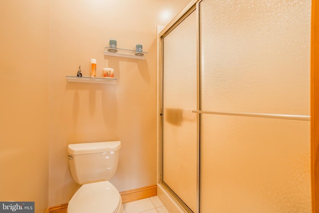 bathroom with tile patterned flooring, a shower with door, and toilet