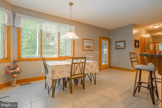 dining space with baseboards, visible vents, and light tile patterned floors