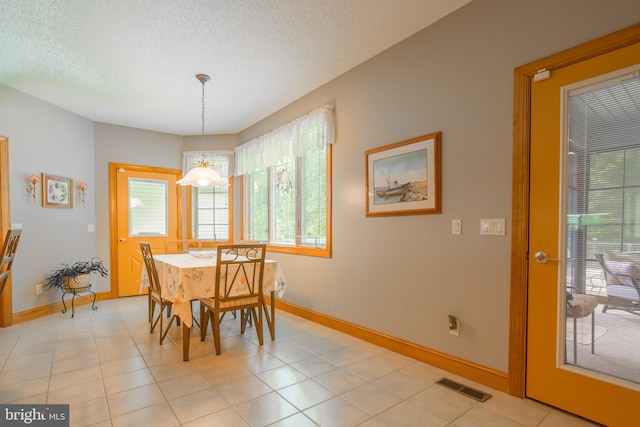 dining area with light tile patterned floors and a textured ceiling