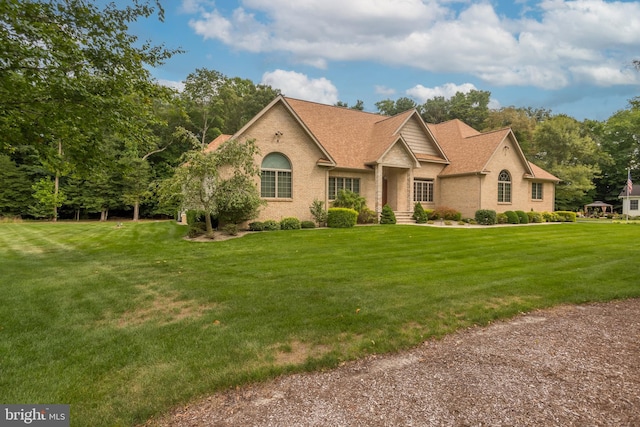 view of front of property featuring brick siding and a front yard