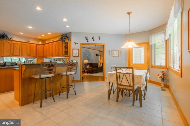 tiled dining space featuring a textured ceiling