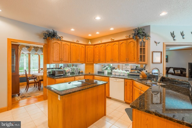 kitchen with a kitchen island, dishwasher, light tile patterned floors, sink, and a textured ceiling