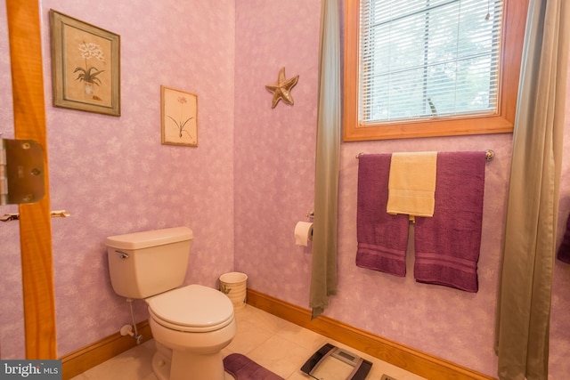 half bath featuring wallpapered walls, toilet, baseboards, and tile patterned floors