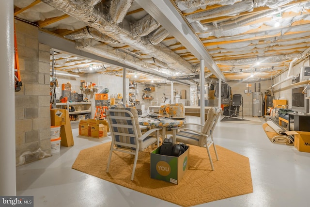 dining space featuring a workshop area, concrete flooring, and electric water heater