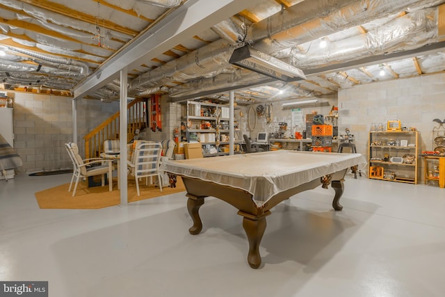 rec room featuring finished concrete flooring and concrete block wall