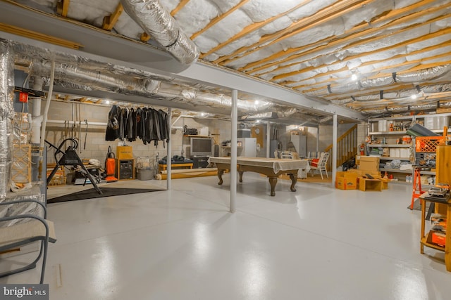 unfinished basement featuring stairs and concrete block wall