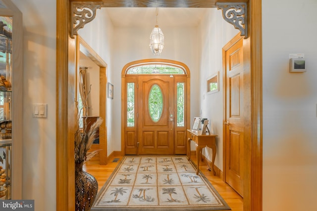 foyer entrance with light wood-style flooring and baseboards