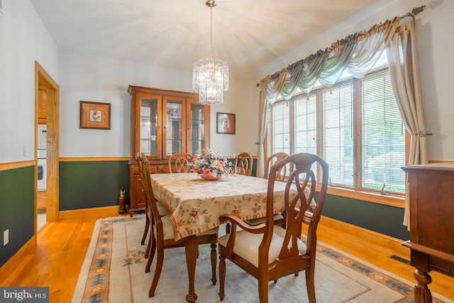 dining room featuring light hardwood / wood-style flooring and a chandelier