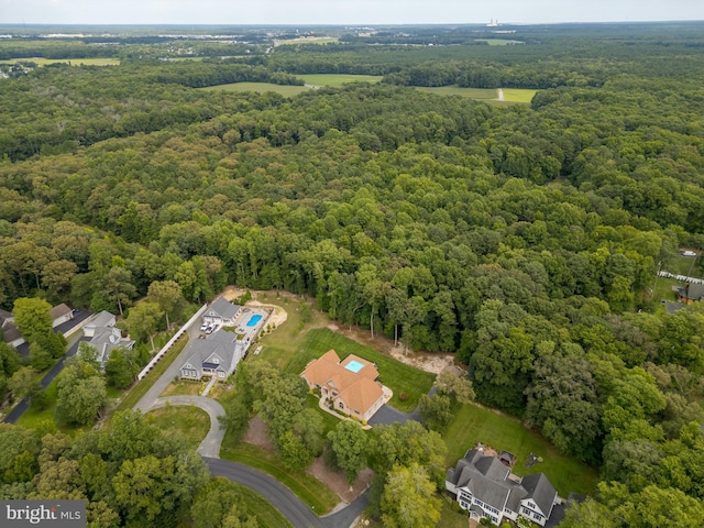 drone / aerial view with a wooded view