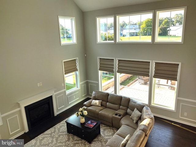 living room with vaulted ceiling, a decorative wall, a fireplace, and a wealth of natural light