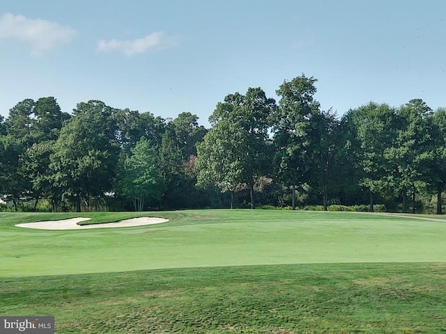 view of property's community featuring a yard and view of golf course