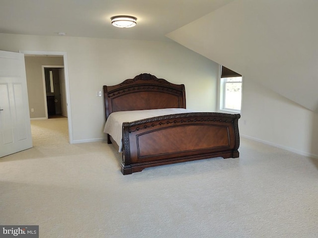 bedroom with vaulted ceiling, light colored carpet, and baseboards