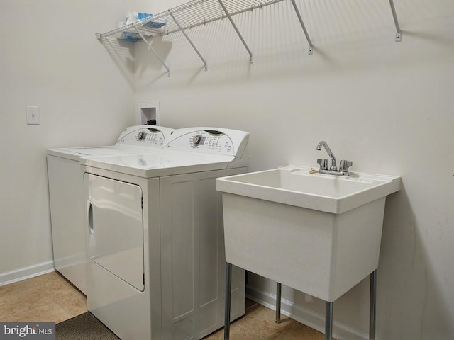 laundry room featuring light tile patterned floors, baseboards, washing machine and dryer, and laundry area