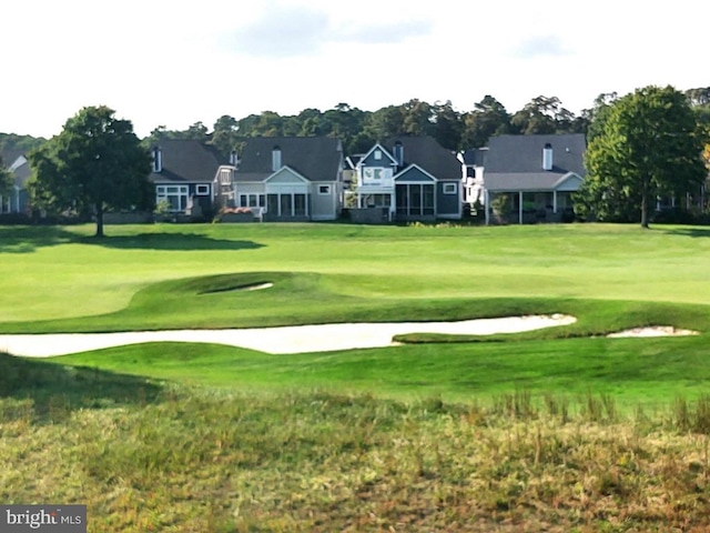 view of community with golf course view and a lawn