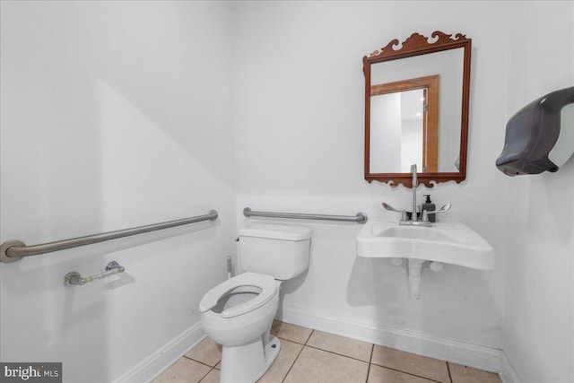 bathroom with tile patterned flooring, toilet, and baseboards