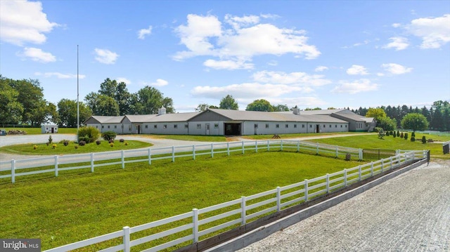 single story home featuring a rural view, a front lawn, and fence