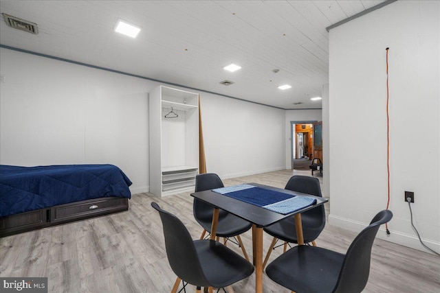 dining space with light wood finished floors, visible vents, and baseboards