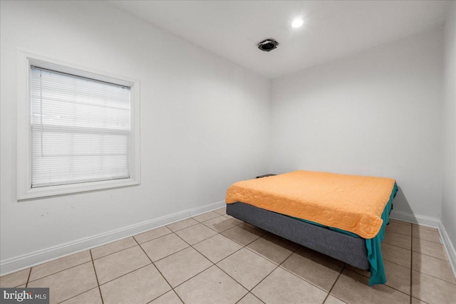 bedroom featuring light tile patterned floors and baseboards