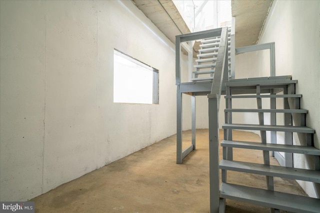 stairs featuring unfinished concrete floors