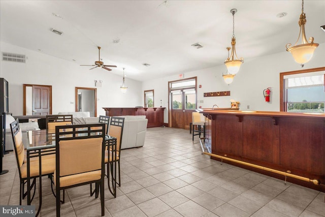 tiled dining space featuring a wealth of natural light, vaulted ceiling, and ceiling fan