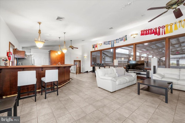 living room featuring plenty of natural light, a ceiling fan, and visible vents