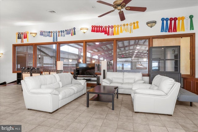 living room with tile patterned flooring, visible vents, and ceiling fan