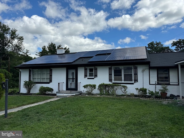 single story home with solar panels and a front yard