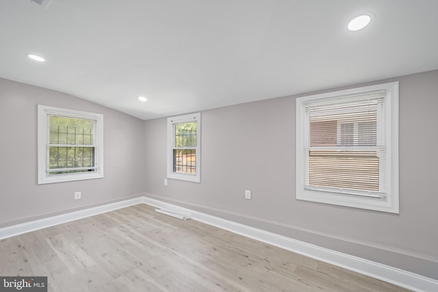 unfurnished room featuring vaulted ceiling and light wood-type flooring